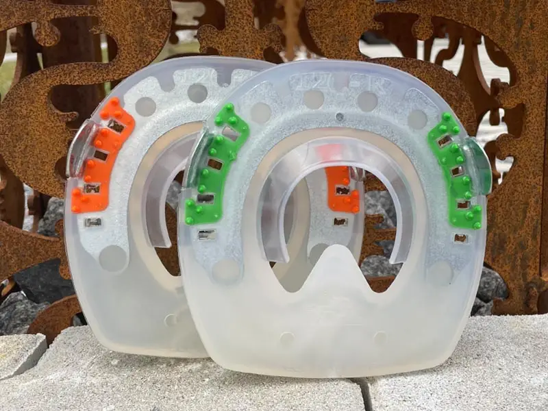Fers alternatifs en plastique souple et dur avec inserts orange et verts pour éviter une rotation sur le sabot.