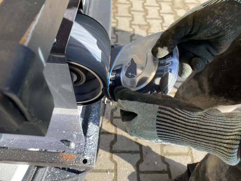 Der Hufschmied passt den günstigeren Hufschutz, den Basic, mit dem Bandschleifer an die Hufform an.