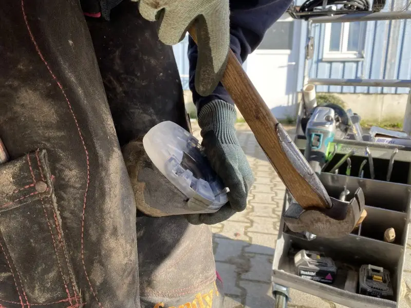 Der Hufschmied nagelt das günstigere Modell, den Basic Hufbeschlag, an den Huf.