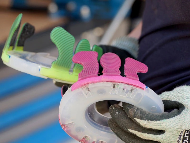 Vue détaillée de la ferrure collée terminée avec des languettes roses et vertes et une plaque de base Nailless.