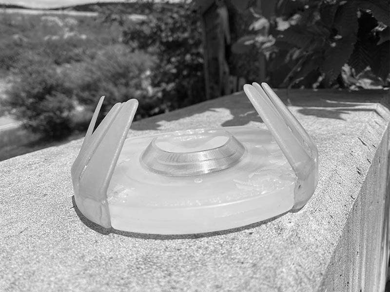 una ferratura adesive costituita da una ferratura in plastica e da una linguetta adesiva divisa in due si trova su un muro di cemento