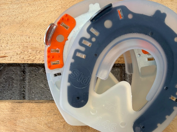 Ein Full Branch Shoe mit regulärem Hufeisenschenkel ohne Noppeneinleger liegt über einem normalen Duplo mit orangem Noppeneinleger.