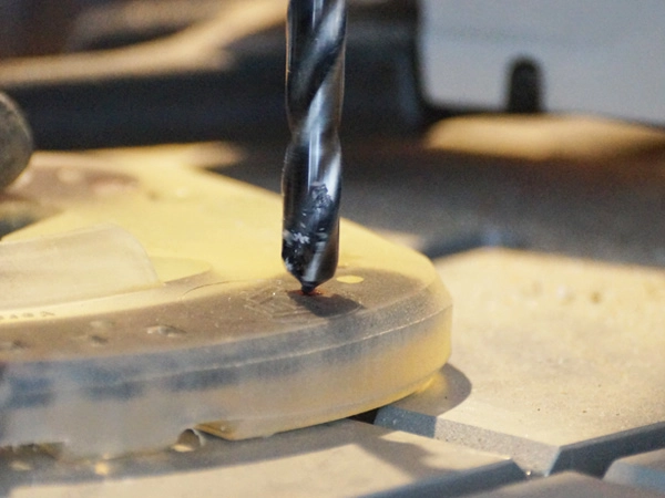 Mit einem HSS-Spiralbohrer wird ein Stollenloch in einen Duplo Full Branch Shoe gebohrt, um einen Stollen zu montieren.