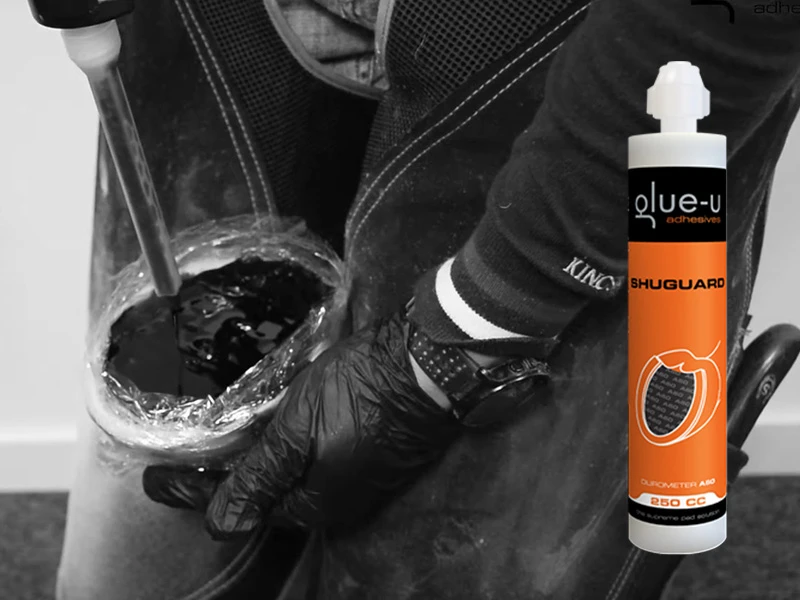 Sullo sfondo si vede uno screenshot dal video con consigli e trucchi di Glue-U sull’utilizzo dello SHUGUARD. In primo piano è visibile la cartuccia SHUGUARD.