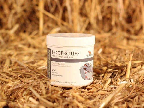 Hoof Stuff von Red Horse steht auf einem Ballen Stroh.