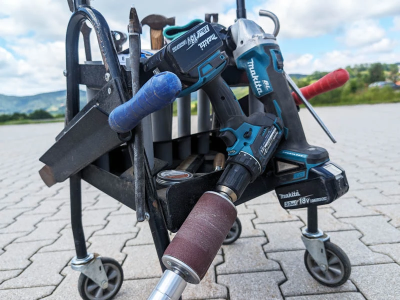 Chariot à outils d’un maréchal-ferrant, avec râpes, meuleuse, buffer, marteau de maréchalerie et autres outils.