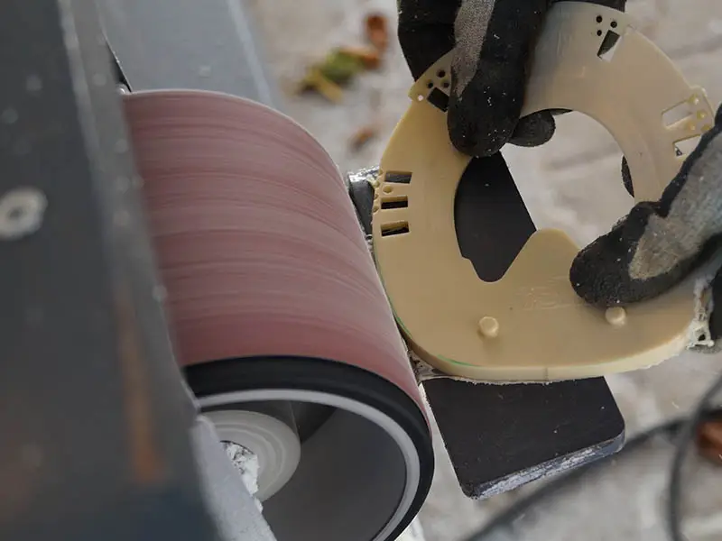 Ajustement d’un fer avec talonnette à la forme du sabot à l’aide d’une ponceuse à bande.