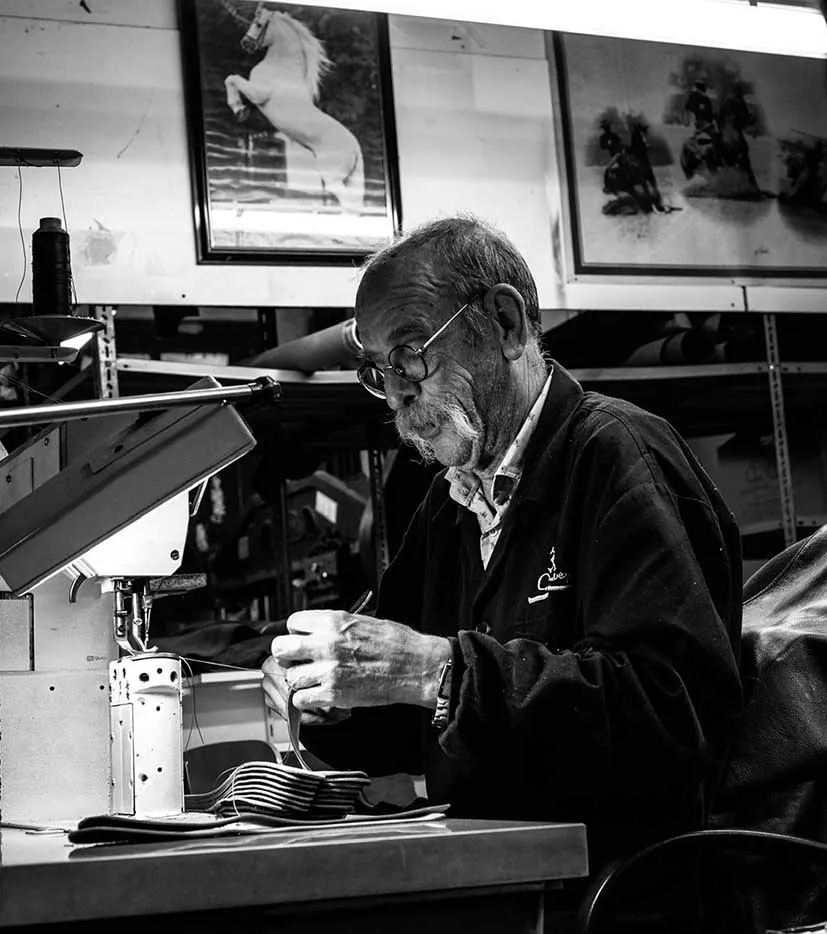 Der Senior-Chef der Firma Con Cuero beim Nähen einer Hufschmiedeschürze.