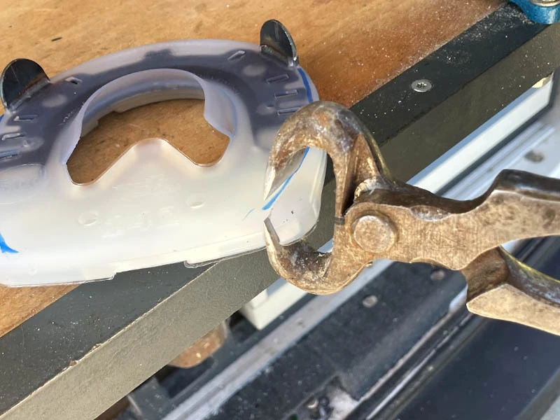 Une ferrure composite est coupée avec une pince à parer pour être ajustée.