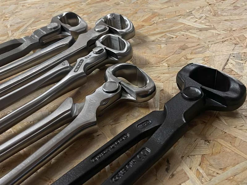 Différents modèles de pinces à parer de plusieurs fabricants sont posés sur un établi.