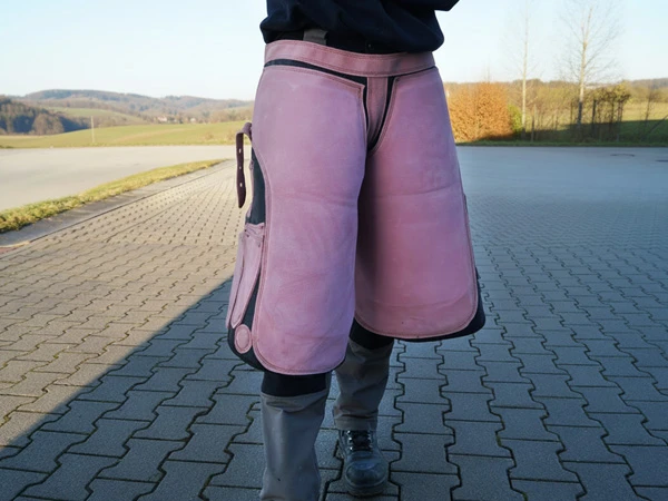 Eine Hufschmiedin trägt die Schmiedeschürze Elite kurz in der Farbe rosa.